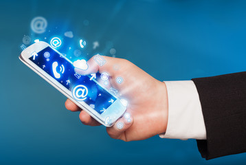 Business man holding smart phone with media icons
