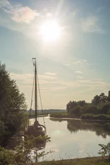 Fototapeten Zeilboot in het Galgenrak nabij Hasselt in Overijssel in de avondschemering in de zomer © Leandervasse