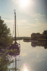 Fototapeten Zeilboot in het Galgenrak nabij Hasselt in Overijssel in de avondschemering in de zomer © Leandervasse