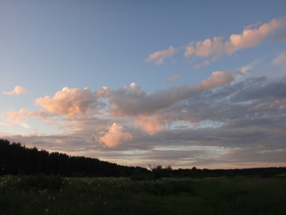 Fototapeta na wymiar Закатные облака розового цвета на голубом небе
