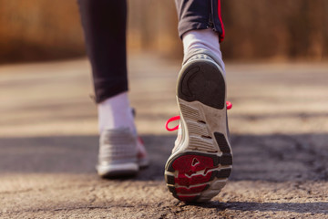 Fototapeta na wymiar Runner feet with sport shoes on road