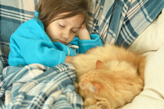 Sleeping  little girl with  red cat