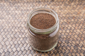Obraz na płótnie Canvas Dried processed tea leaves in a mason jar over rustic wicker background