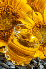 Fresh sunflower oil in a glass with flowers sunflowers and sunfl