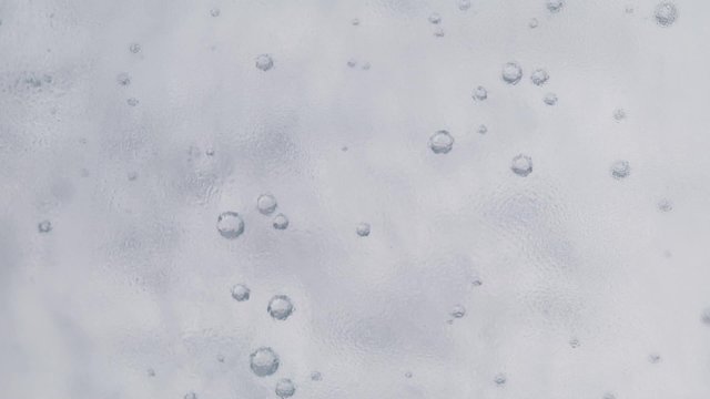 Super close-up of gas bubbles in the water outside the glass condensate