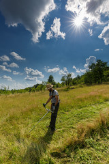 Young farmer mowing grass