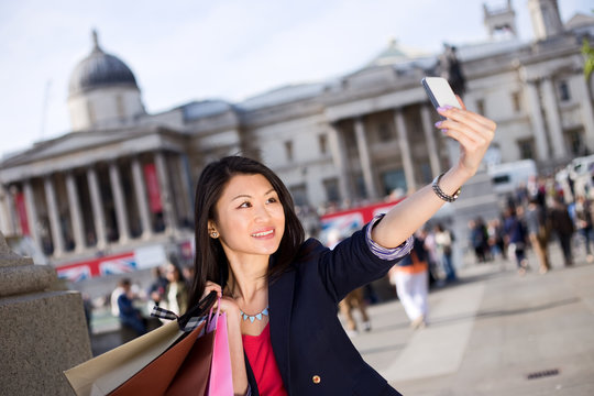 young chinese tourist taking a selfie in london