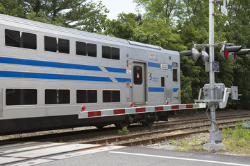 Obraz premium MTA Long Island Railroad train passing a level crossing at Mattituck USA