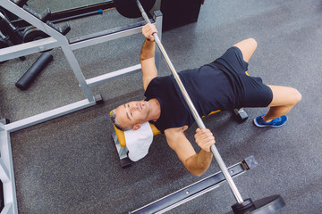 Man with barbell on a bench press training