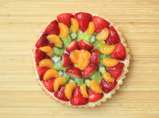 A delicious homemade fruit flan on a wooden table.