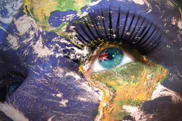 womans face with planet Earth texture and tuvalu flag inside the eye.