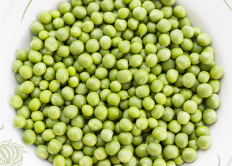 Green peas on the white plate background