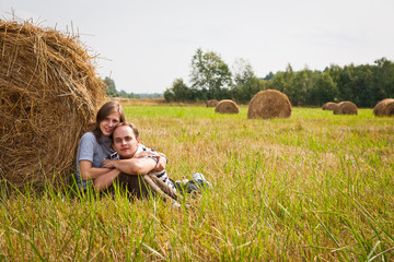 Naklejka na ściany i meble Young loving couple on the haystack
