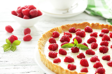 Sweet tart cake with raspberries on white wooden background