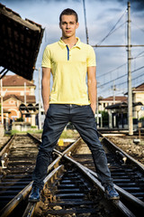 Attractive young man standing on railroad