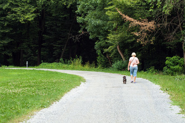 Woman walking a dog in the park