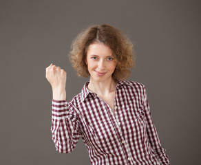 Happy young woman showing a gesture of effort