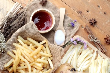 Fototapeta na wymiar French fries and fresh sliced potatoes with ketchup.