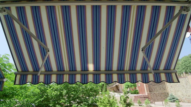 Folding retractable awning mounted onto the outside wall of house