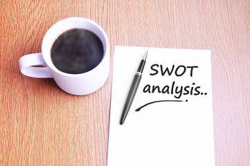 Coffee, pen and notes write swot analysis