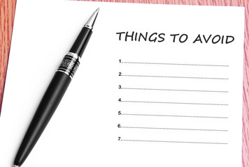 Pen  and notes paper with things to avoid list
