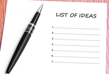 Pen  and notes paper with list of ideas