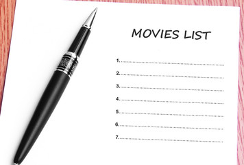 Pen  and notes paper with movies list