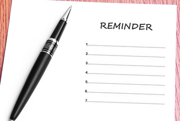 Pen  and notes paper with reminder list