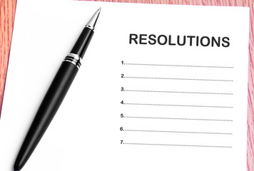 Pen  and notes paper with resolutions list