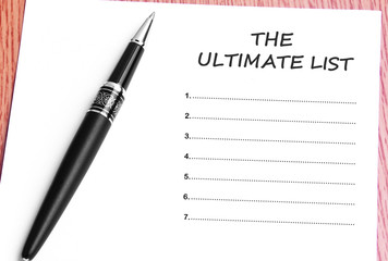 Pen  and notes paper with the ultimate list