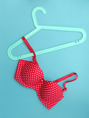 Summer concept, bra on coat hanger on blue. (Pop art style)