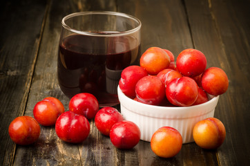 Fresh plum (Julee) and juice on wooden background