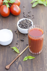 Tomato juice in glass with basil, spices and tomatoes cherry, selective focus