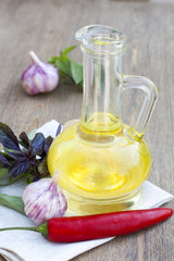 Sunflower oil in the bottles with herbs and spices on wooden table, selective focus