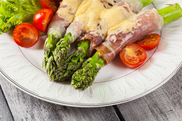 Baked green asparagus with prosciutto and cheese