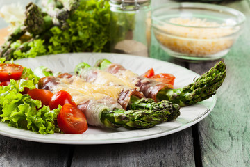 Baked green asparagus with prosciutto and cheese
