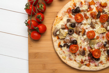 Pizza with bacon, olives and tomato