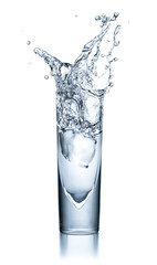 Glas mit klarer Flüssigkeit mit Eiswürfel und Spritzern