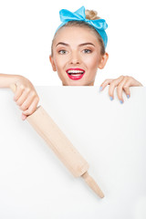 Cheerful young woman is hiding behind white barrier