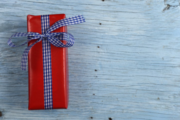 Gift box with ribbon on old wooden table