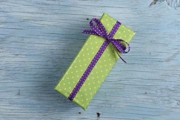 Gift box with ribbon on old wooden table
