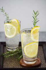 Lemonade with fresh lemon and rosemary in glass