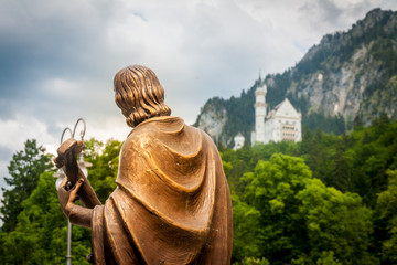 Statue looks towards the Neuschwanstein castle, in Fussen