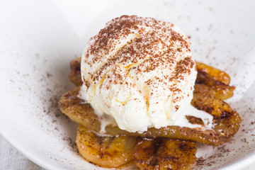 pan fried banana topped with vanilla ice cream and cocoa powder