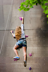 woman climbing artificial rock wall