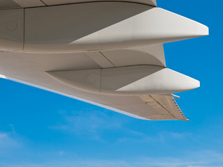 White jumbo wing flap details isolated on blue sky