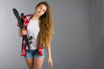 portrait of a girl with a skateboard in the Studio