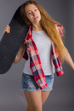 portrait of a girl with a skateboard in the Studio