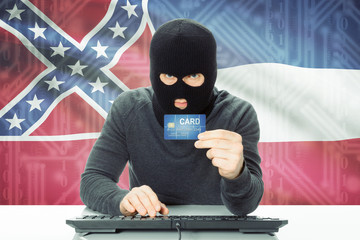 Hacker holding credit card and USA state flag on background - Mississippi