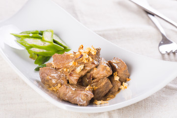 beef salpicao, or beef with creamy soy sauce topped with toasted garlic